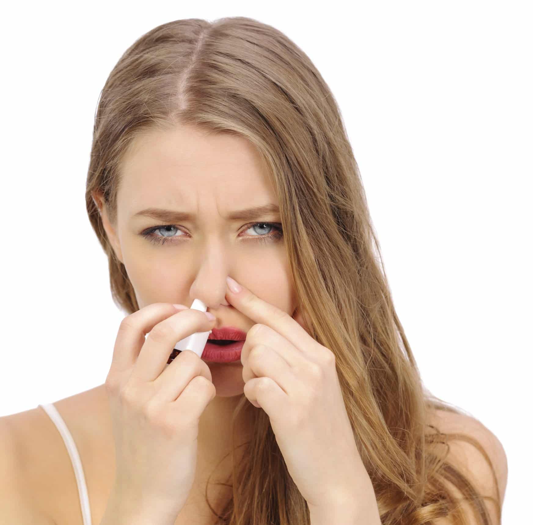 sick woman with nasal spray